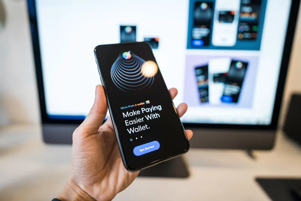 Hand holding a smartphone showing a digital wallet app